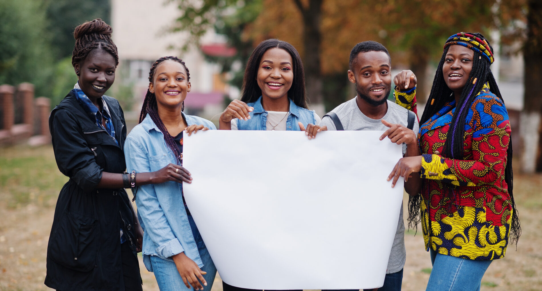 Group of five african college students on campus at university yard hold empty white blank. Free space for your text. Black afro friends studying.